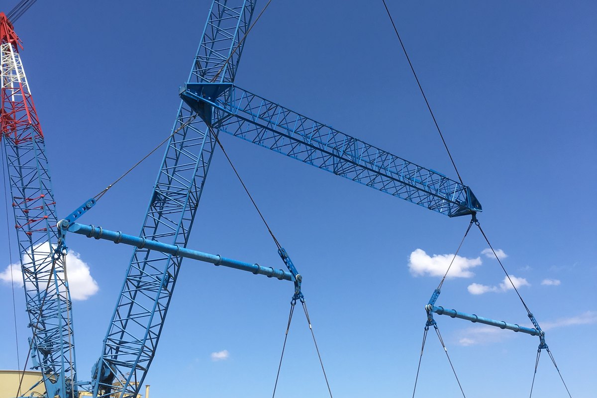 A crawler crane lifting a lattice section on spreader bars at Lake Cowal