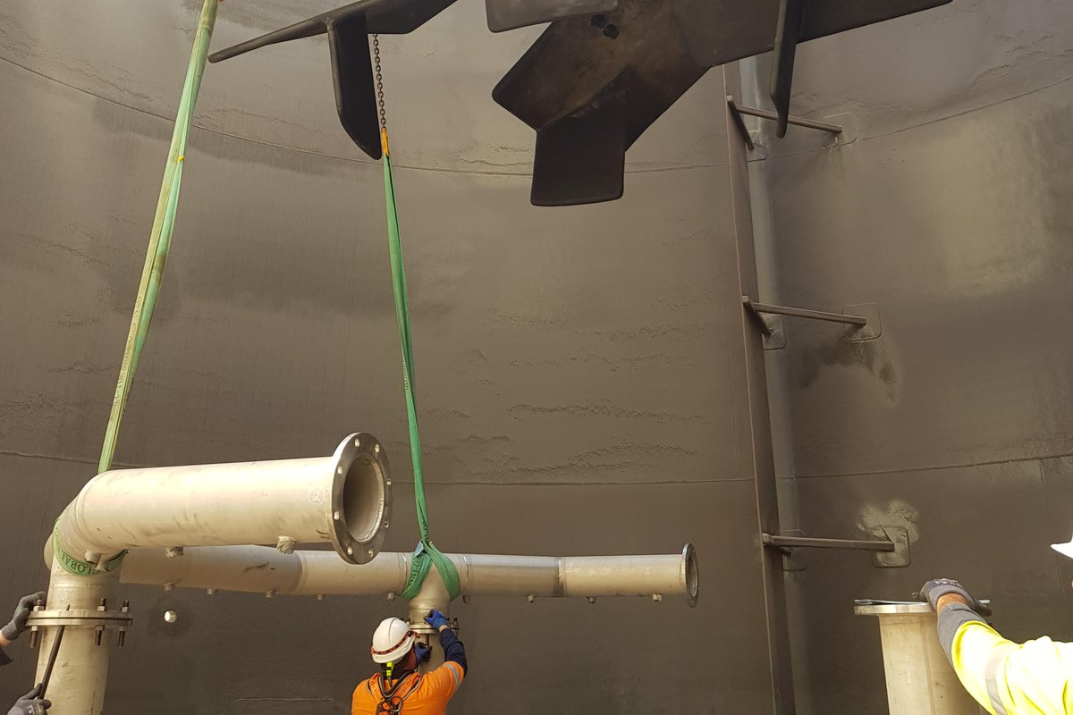 A rigger in a tank at Lake Cowal guiding a slung agitator into place